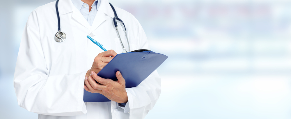 A physician in a white coat reviewing a patient chart