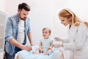 Dad worrying about baby getting a shot.